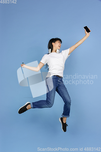 Image of Portrait of young asian woman isolated on blue studio background