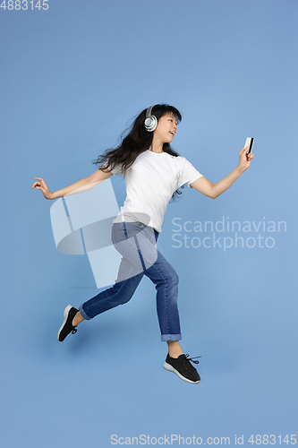 Image of Portrait of young asian woman isolated on blue studio background