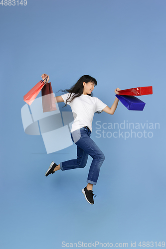 Image of Portrait of young asian woman isolated on blue studio background