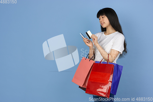 Image of Portrait of young asian woman isolated on blue studio background