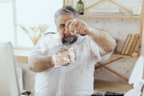 Image of Businessman, manager in office with computer and fan cooling off, feeling hot, flushed