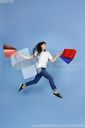 Image of Portrait of young asian woman isolated on blue studio background