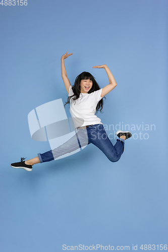 Image of Portrait of young asian woman isolated on blue studio background