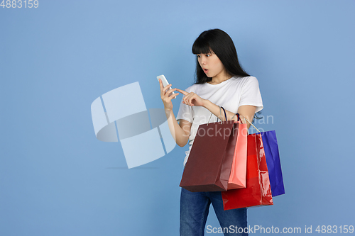 Image of Portrait of young asian woman isolated on blue studio background