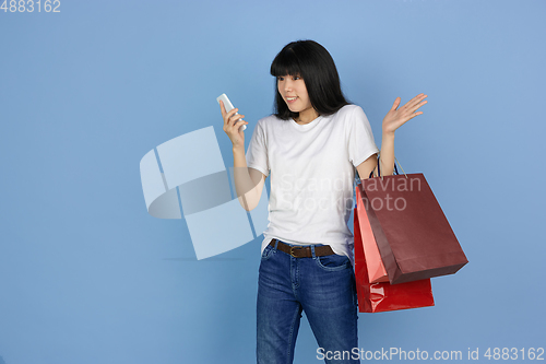 Image of Portrait of young asian woman isolated on blue studio background