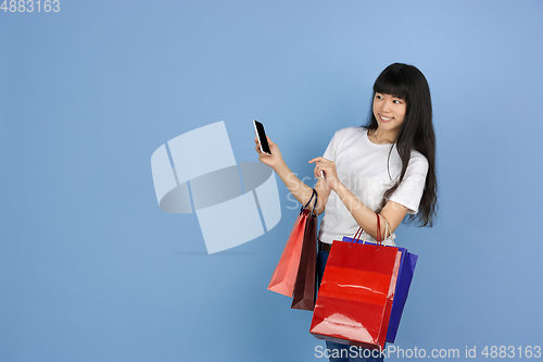 Image of Portrait of young asian woman isolated on blue studio background