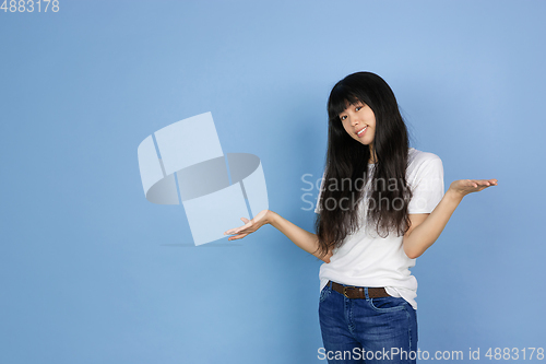 Image of Portrait of young asian woman isolated on blue studio background