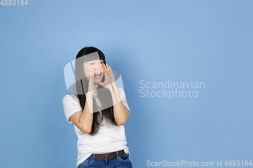 Image of Portrait of young asian woman isolated on blue studio background