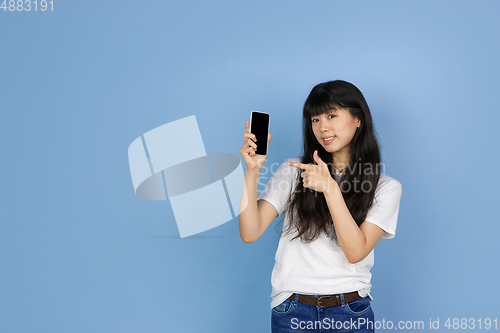 Image of Portrait of young asian woman isolated on blue studio background