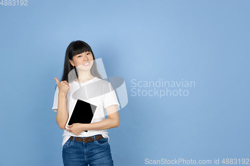 Image of Portrait of young asian woman isolated on blue studio background