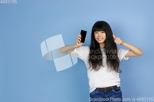 Image of Portrait of young asian woman isolated on blue studio background