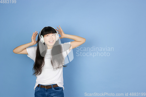 Image of Portrait of young asian woman isolated on blue studio background