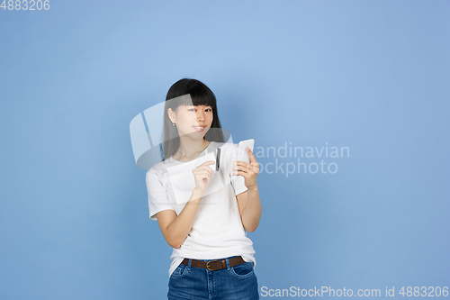Image of Portrait of young asian woman isolated on blue studio background