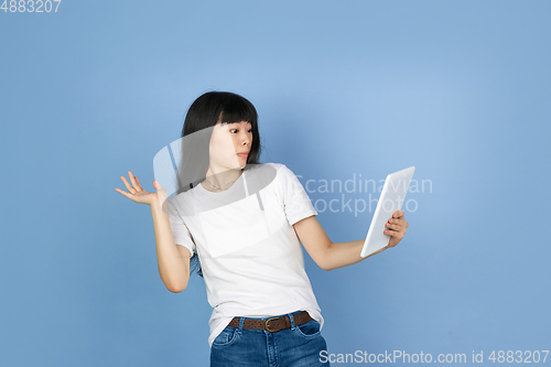 Image of Portrait of young asian woman isolated on blue studio background