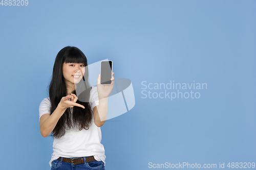 Image of Portrait of young asian woman isolated on blue studio background