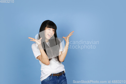 Image of Portrait of young asian woman isolated on blue studio background