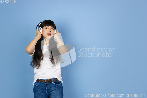 Image of Portrait of young asian woman isolated on blue studio background