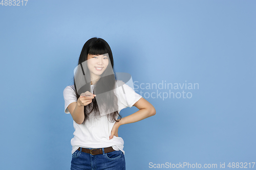 Image of Portrait of young asian woman isolated on blue studio background