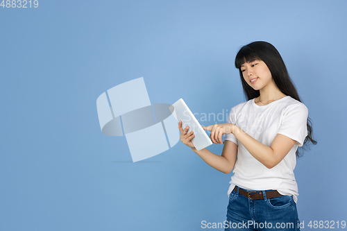 Image of Portrait of young asian woman isolated on blue studio background