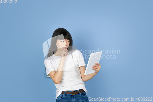 Image of Portrait of young asian woman isolated on blue studio background
