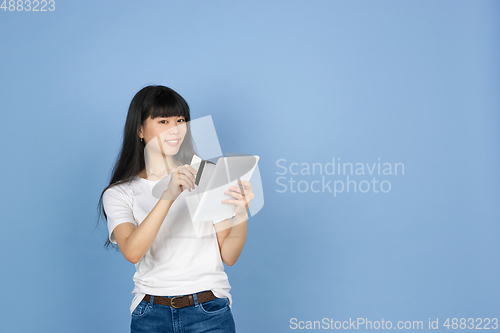 Image of Portrait of young asian woman isolated on blue studio background