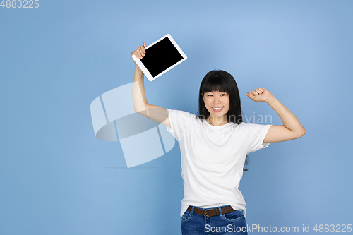 Image of Portrait of young asian woman isolated on blue studio background