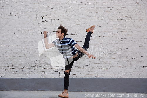 Image of Jumping young buinessman in front of buildings, on the run in jump high