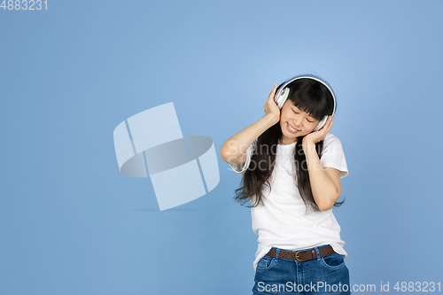 Image of Portrait of young asian woman isolated on blue studio background