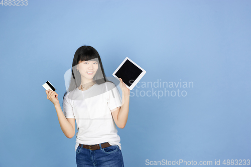 Image of Portrait of young asian woman isolated on blue studio background