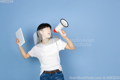 Image of Portrait of young asian woman isolated on blue studio background