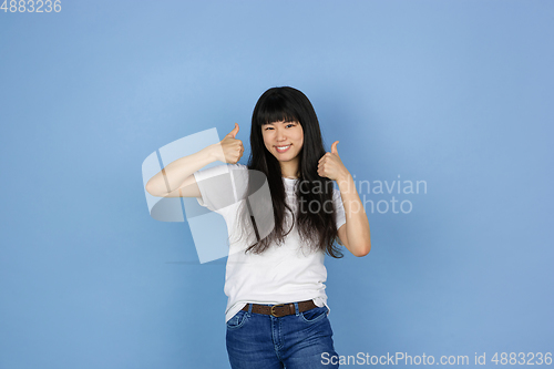 Image of Portrait of young asian woman isolated on blue studio background