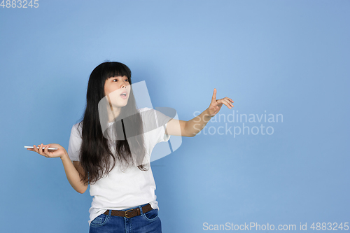 Image of Portrait of young asian woman isolated on blue studio background
