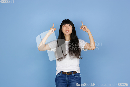 Image of Portrait of young asian woman isolated on blue studio background