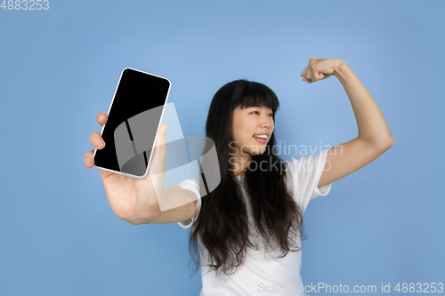 Image of Portrait of young asian woman isolated on blue studio background