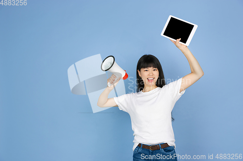 Image of Portrait of young asian woman isolated on blue studio background