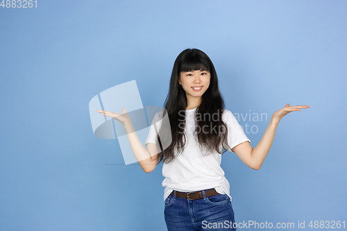Image of Portrait of young asian woman isolated on blue studio background