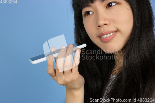 Image of Portrait of young asian woman isolated on blue studio background