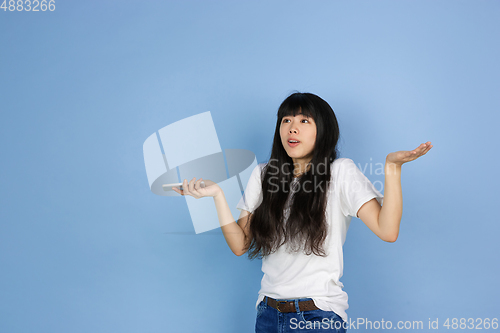 Image of Portrait of young asian woman isolated on blue studio background