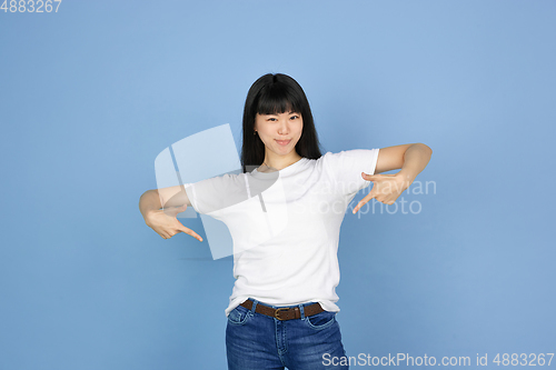 Image of Portrait of young asian woman isolated on blue studio background