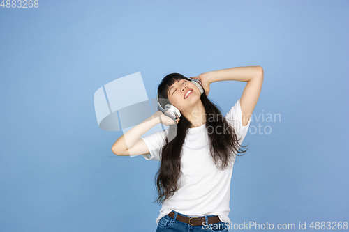 Image of Portrait of young asian woman isolated on blue studio background