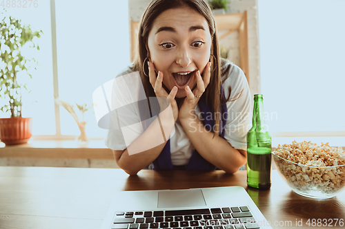 Image of Excited football fan watching sport match at home, remote support of favourite team during coronavirus pandemic outbreak