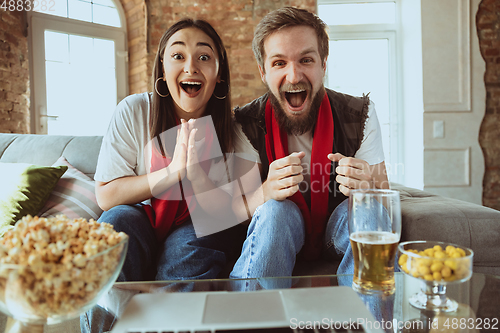 Image of Excited football fans watching sport match at home, remote support of favourite team during coronavirus pandemic outbreak