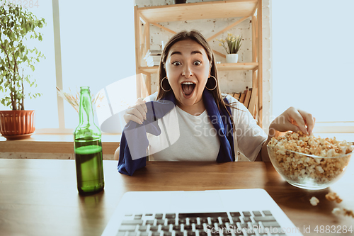 Image of Excited football fan watching sport match at home, remote support of favourite team during coronavirus pandemic outbreak