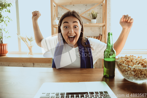 Image of Excited football fan watching sport match at home, remote support of favourite team during coronavirus pandemic outbreak