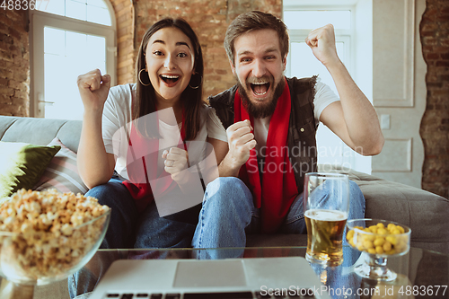 Image of Excited football fans watching sport match at home, remote support of favourite team during coronavirus pandemic outbreak