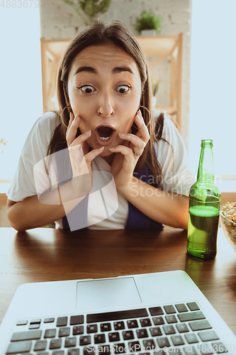 Image of Excited football fan watching sport match at home, remote support of favourite team during coronavirus pandemic outbreak