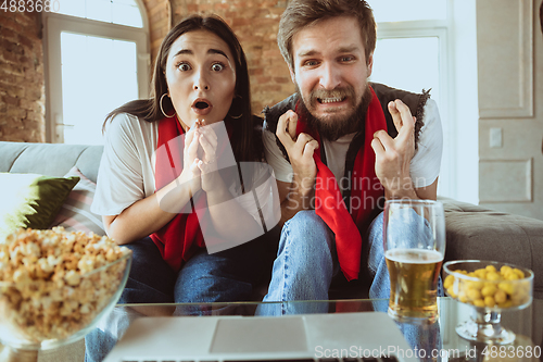 Image of Excited football fans watching sport match at home, remote support of favourite team during coronavirus pandemic outbreak