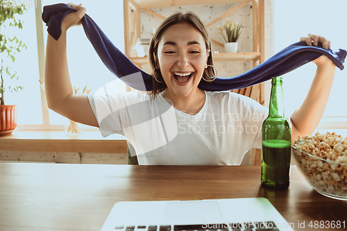 Image of Excited football fan watching sport match at home, remote support of favourite team during coronavirus pandemic outbreak