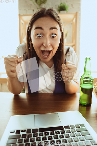 Image of Excited football fan watching sport match at home, remote support of favourite team during coronavirus pandemic outbreak