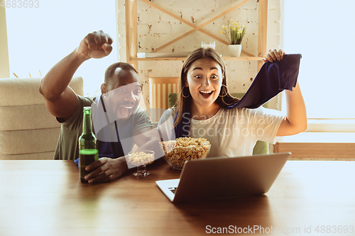 Image of Excited football fans watching sport match at home, remote support of favourite team during coronavirus pandemic outbreak